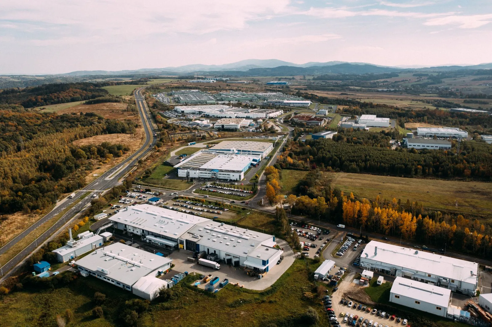 Vista aérea de parque industrial e logístico cercado por mata e campo